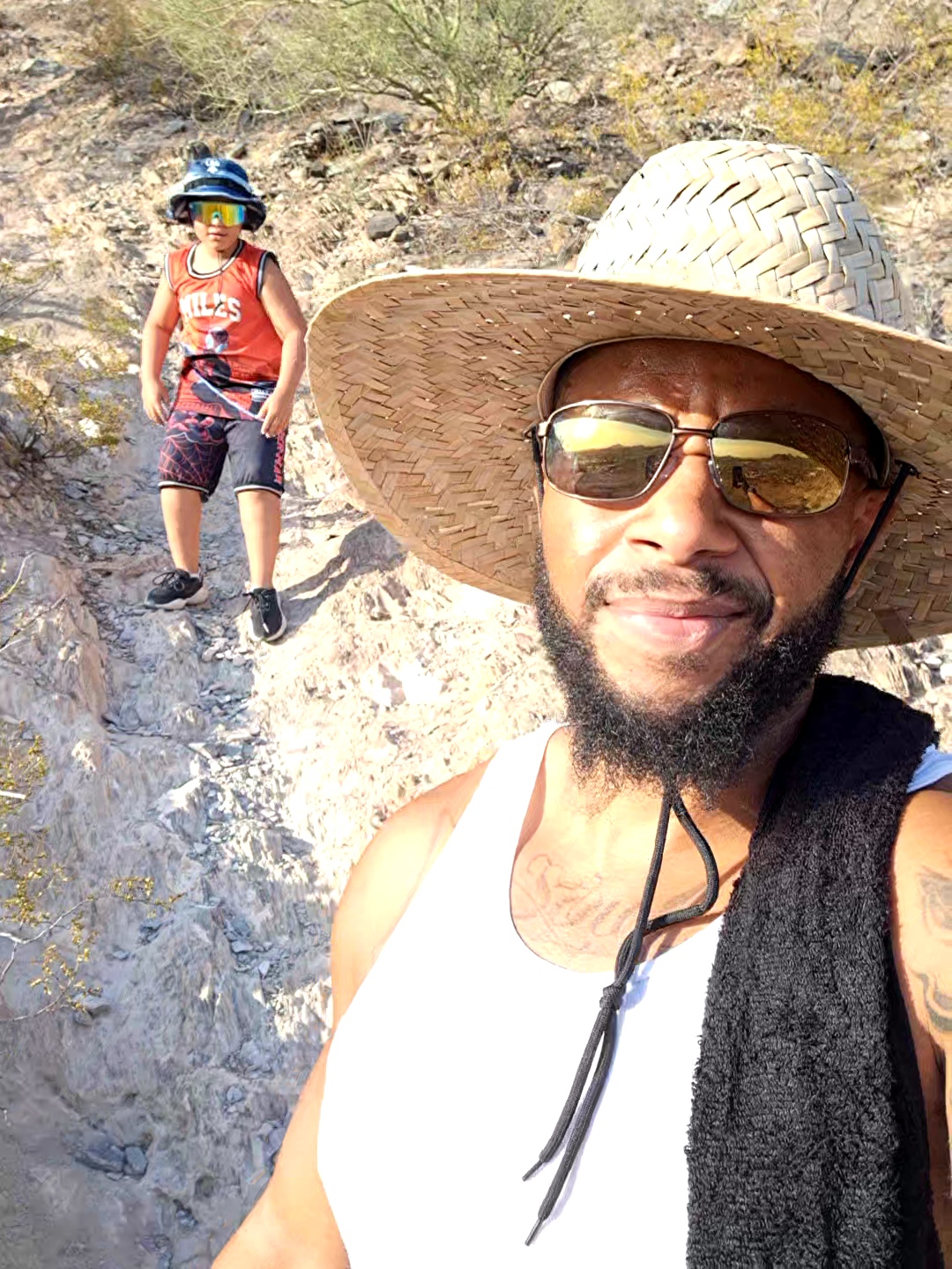 Ron outdoors wearing a straw hat and sunglasses