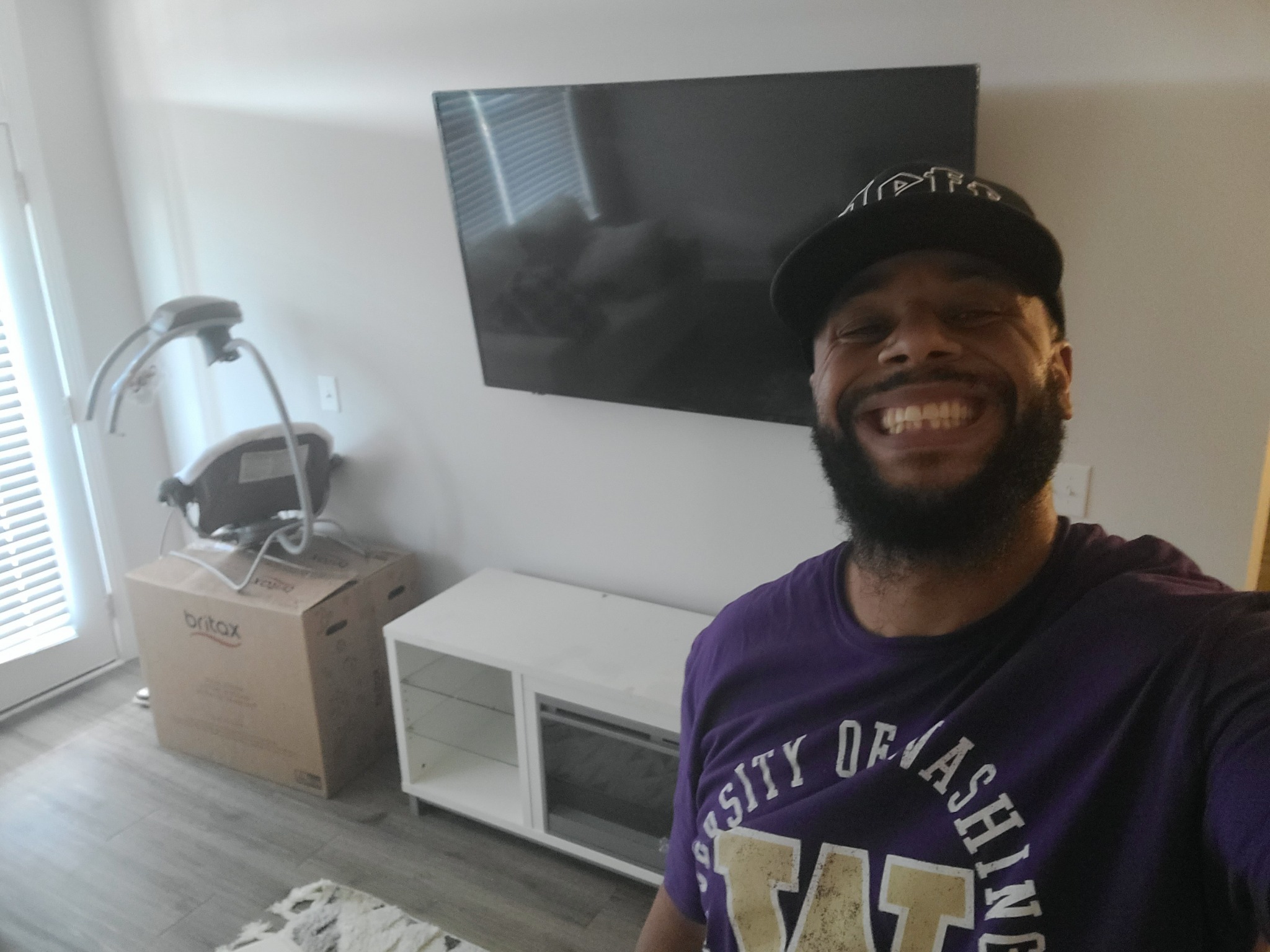 Ron smiling in front of a mounted TV