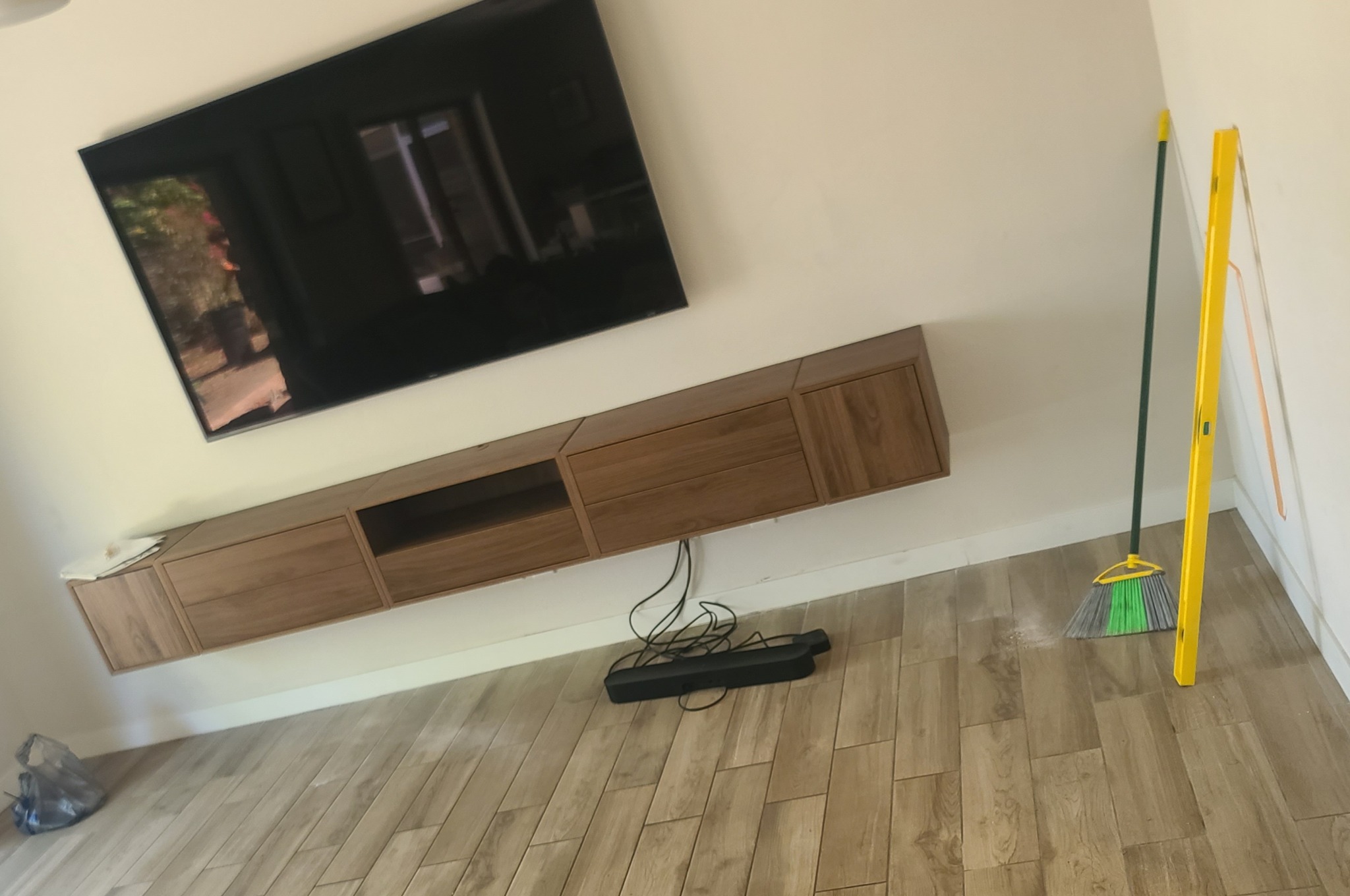 Wall-mounted TV above a floating wooden media console
